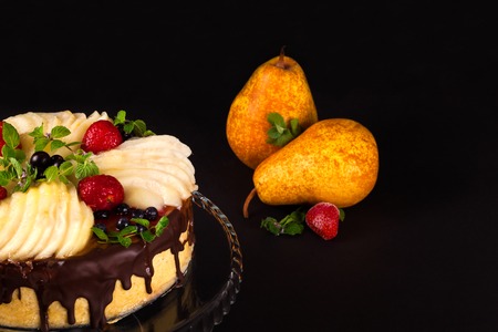 Cake with dark chocolate mousse, pear confit, fruits and berries on top as decoration. Tea party with homemade fresh cake.の写真素材