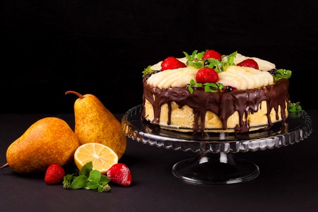 Cake with dark chocolate mousse, pear confit, fruits and berries on top as decoration. Tea party...