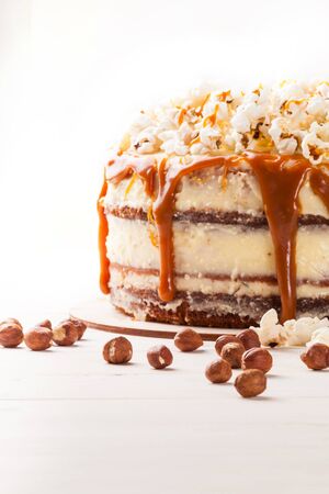 Homemade cake with hazelnuts and salty caramel with vanilla - hazel shortcakes and delicate hazelnut cream, decorated with salty popcorn. Close up.の写真素材