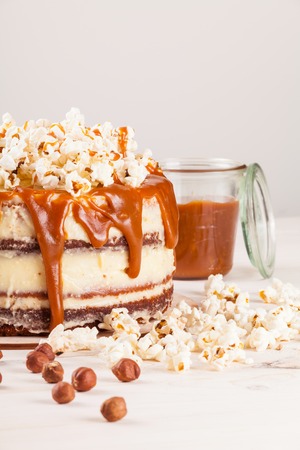 Homemade cake with hazelnuts and salty caramel with vanilla - hazel shortcakes and delicate hazelnut cream, decorated with salty popcorn.の写真素材