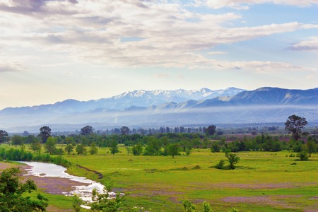 Valley view from the river and the mountains in the background at sunrise. Georgia. Caucasus mountainsの写真素材