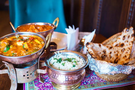 A variety of Indian food with rice in oriental bowlsの写真素材