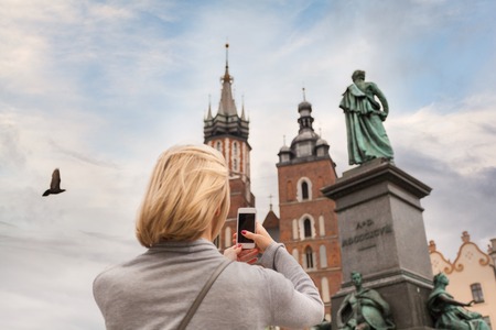 Young beautiful woman on the background of the St. Marys Church in Krakowの写真素材