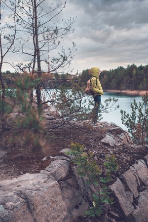 Young girl with backpack enjoying the view of the lake.の写真素材