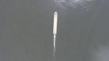 Long barge floating on the Dnieper river. Aerial view. Top view