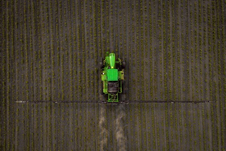 The tractor spraying the field with chemicals in the springの写真素材