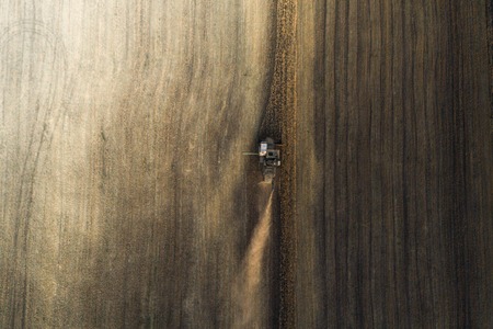 Harvester working in field and mows wheat. Ukraine. Aerial view.の写真素材