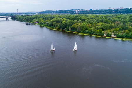 Two yachts are rafted along the Dnieper River. Sailing sport. Competitions on the waterの写真素材