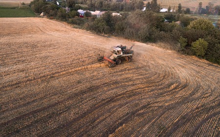 Harvester working in field and mows wheat. Ukraine. Aerial view.の写真素材