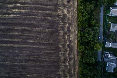 Panoramic view of the valley with green fresh fields and village. Aerial view of countryside