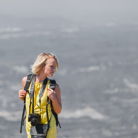 Female traveler with a backpack on her back enjoying the views from the mountains of Montserrat in Spainの写真素材