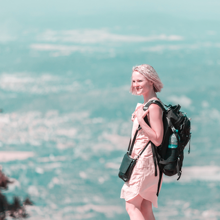 Female traveler with a backpack on her back enjoying the views from the mountains of Montserrat in Spainの写真素材