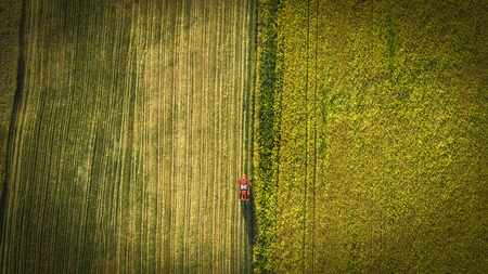 Agricultural machinery in the field. Tractor with a sprayer. Aerial viewの写真素材
