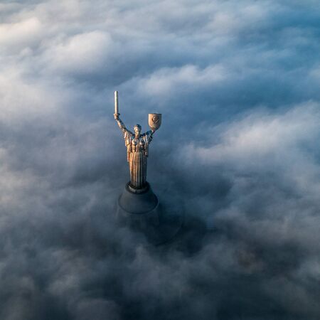 Thick clouds of autumn fog and the Motherland monument sticking out of themのeditorial素材