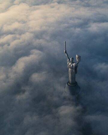 Thick clouds of autumn fog and the Motherland monument sticking out of themのeditorial素材