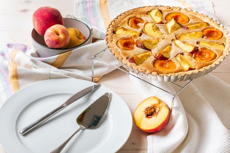 Homemade open peach pie on a white wooden background.の写真素材