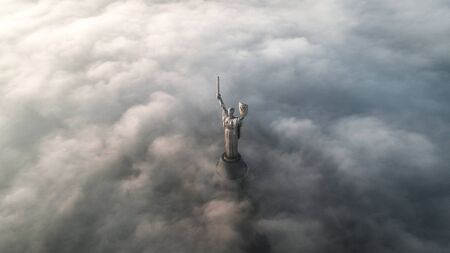 Thick clouds of autumn fog and the Motherland monument sticking out of themのeditorial素材