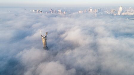 Thick clouds of autumn fog and the Motherland monument sticking out of themのeditorial素材