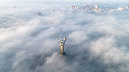 Thick clouds of autumn fog and the Motherland monument sticking out of themのeditorial素材