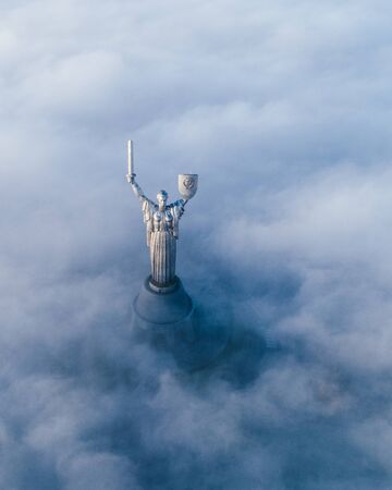 Thick clouds of autumn fog and the Motherland monument sticking out of themのeditorial素材