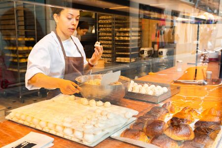 Confectioner woman making sweets in bakery or pastry shopのeditorial素材