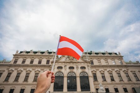 Flag of Austria against the backdrop of the Schonbrunn Palace in Vienna, Austria