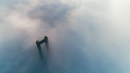 The top of the pylon of the North Bridge or Moscow Bridge in dense dense fog in Kiev, Ukraine. City in the mistの写真素材