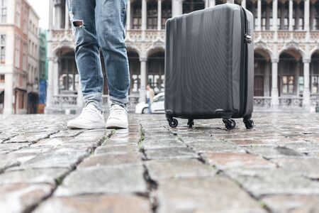 Woman tourist goes with a suitcase at the Grand Place in Brussels, Belgiumの写真素材
