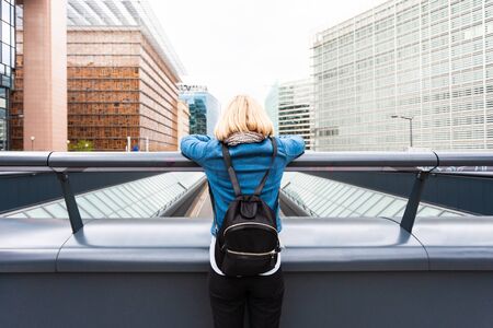 Young woman in casual clothes stands on a bridgeの写真素材