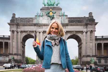 Young woman against Triumphal Arch in Cinquantennaire Park in Brussels, Belgiumの写真素材