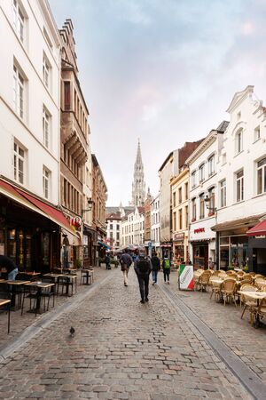 A street in Brussels with many restaurants and the Brussels Town Hall tower in the background, Belgiumのeditorial素材