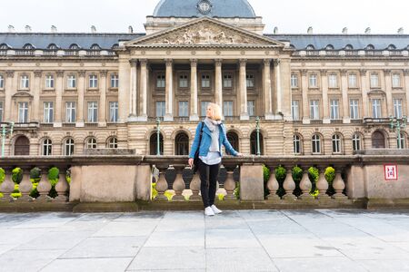 A woman stands against the backdrop of the Royal Palace in Brussels, Belgiumの写真素材