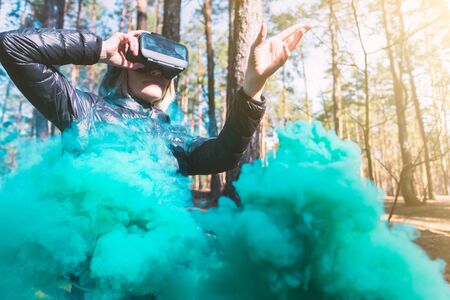 Cheerful girl with hands up wearing the virtual reality goggles.の写真素材