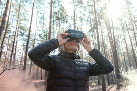 Cheerful girl with hands up wearing the virtual reality goggles.の写真素材