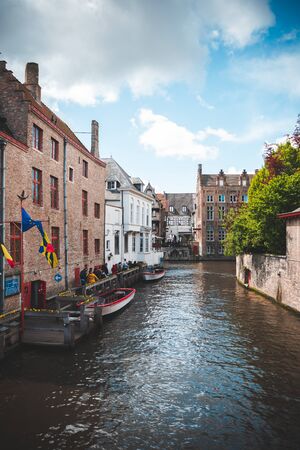 Beautiful landscape on classic houses in the Flemish style with reflection in the water of canals in the historical center of Bruges, Belgiumの写真素材