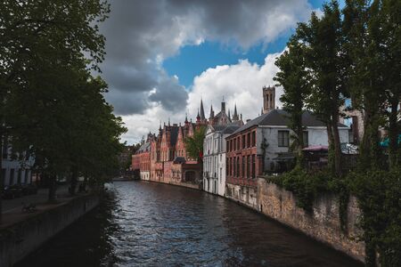 View of the canal with houses in the classic Flemish style in the historical center of Bruges, Belgiumの写真素材