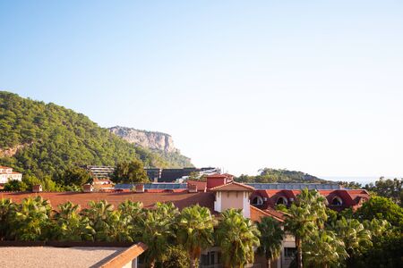 Private white building with red tiled roof in the background of nature and mountains.の写真素材
