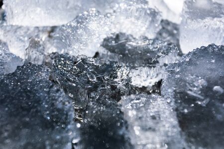 Abstract background with broken pieces of ice of natural origin on a dark background.の写真素材