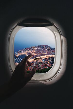 The male hand points a finger towards the aerial panorama of the city of Old Town Dubrovnik,...