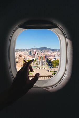 Airplane window with a aerial panorama of Barcelona, Spain with city panorama during a flightの写真素材