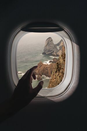 Airplane window with a aerial panorama of Ursa beach near Cabo da Roca in Portugal during a flightの写真素材