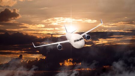 Airplane in the cloudy sky at sunset - Passenger Airliner or aircraftの写真素材