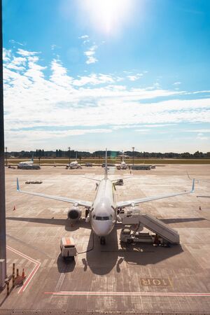 The plane is loading passengers at the airport. View of the aircraft from the passenger terminalの写真素材