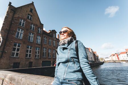 Woman tourist sitting and enjoying a center of Bruges, Belgiumの写真素材