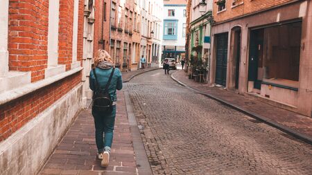 A woman walks along an empty street in Bruges, Belgium.の写真素材