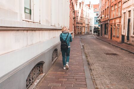 A woman walks along an empty street in Bruges, Belgium.の写真素材