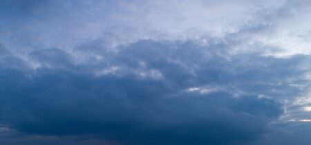 Dark cloudy sky with red reflections at sunsetの写真素材