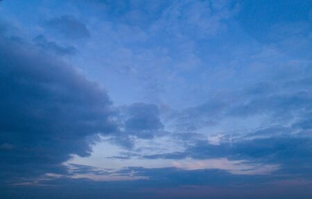 Dark cloudy sky with red reflections at sunsetの写真素材
