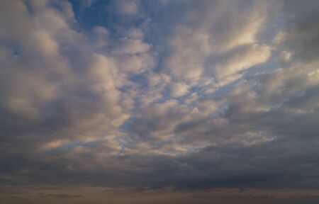 Dark cloudy sky with red reflections at sunsetの写真素材