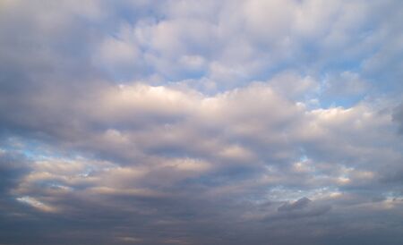 Dark cloudy sky with red reflections at sunsetの写真素材